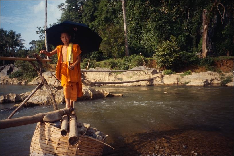 Monk crossing river at Tham Xang near Vang Vieng, Laos