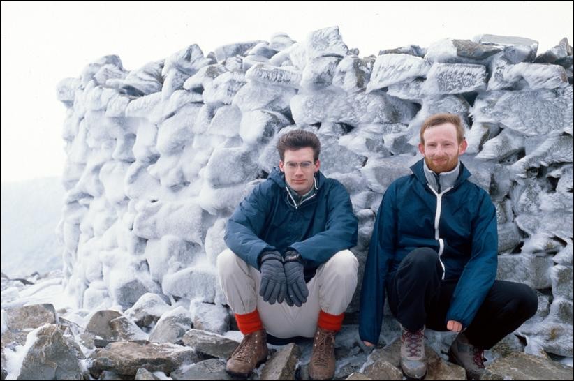 Jon and Kevin crouching on the icy summit of Scafell Pike, Lake District, England